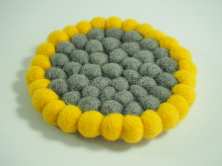 Okrągła podkładka dekoracyjna pod kubek z wełnianych kulek o średnicy 10 cm